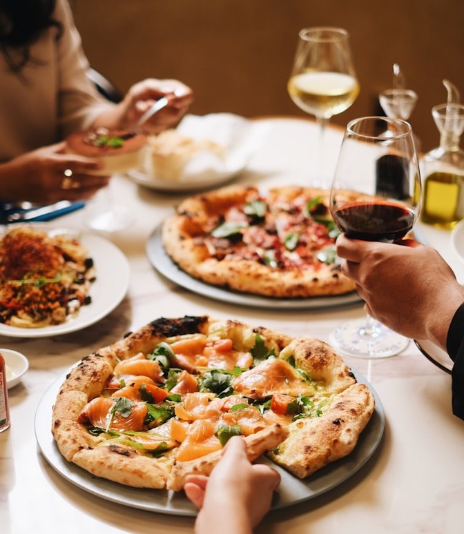 A group of people sitting around a table eating pizza